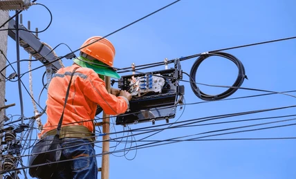 Technician on pole installing internet cables